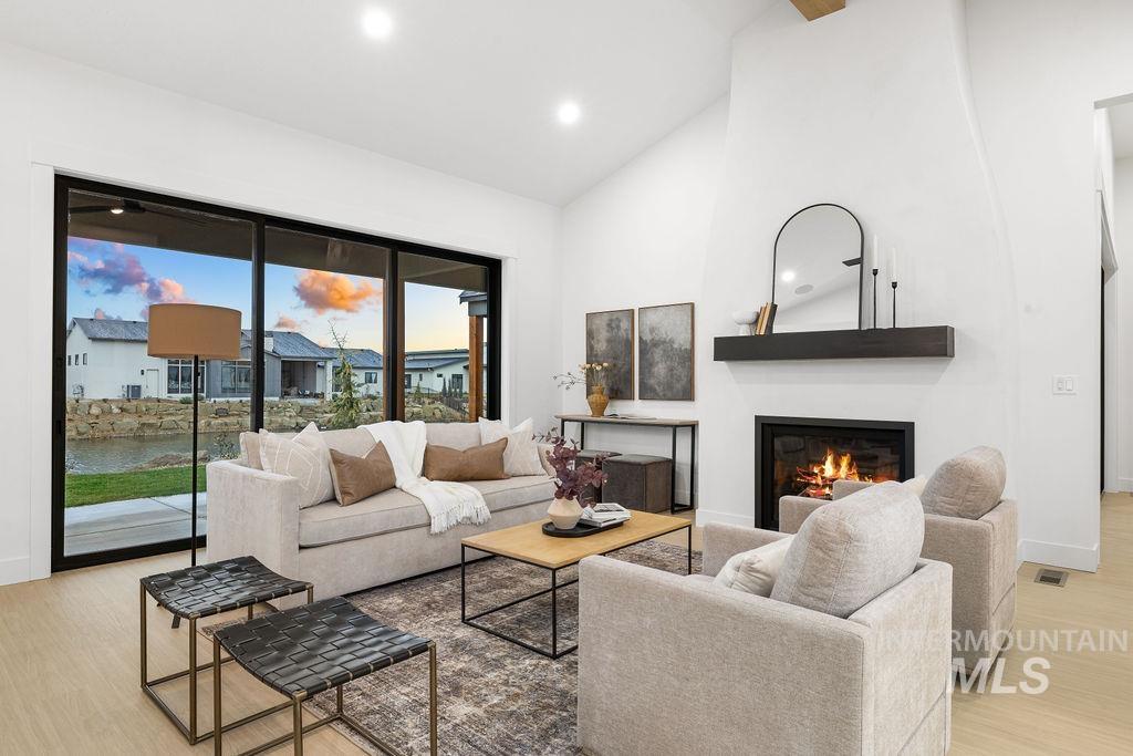 494 Century Avenue Middleton, ID 83644 - Photo 8 of 50 Living area with a glass covered fireplace, light wood finished floors, high vaulted ceiling, and recessed lighting