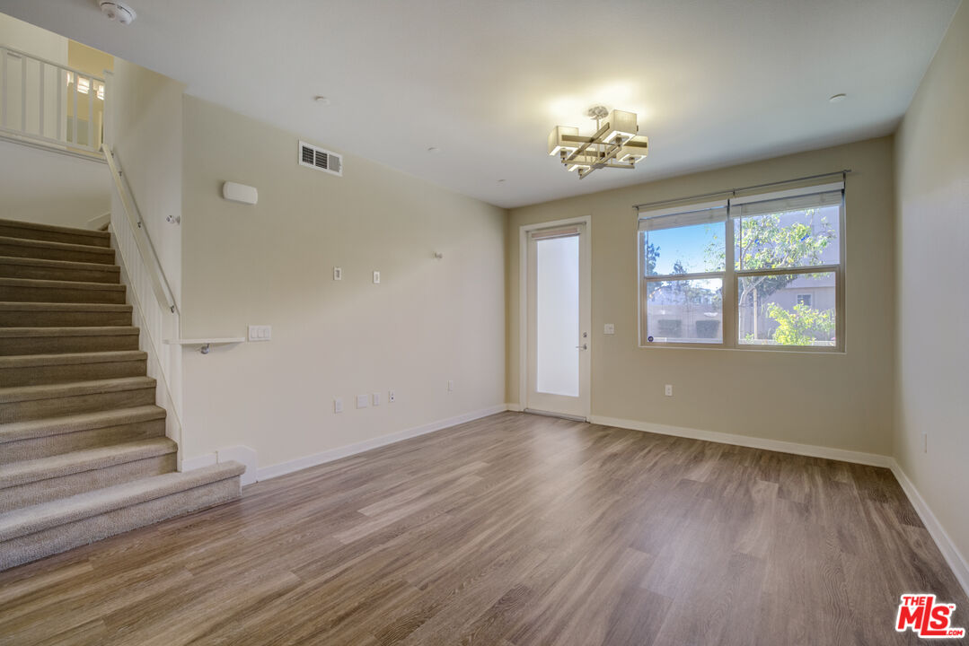 694 Colorado Circle Carson, CA 90745 - Photo 12 of 37 a view of an empty room with wooden floor and a window