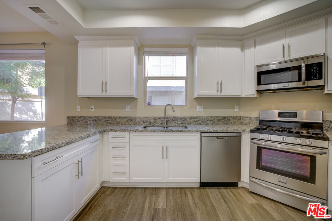 694 Colorado Circle Carson, CA 90745 - Photo 16 of 37 a kitchen with stainless steel appliances granite countertop a stove a sink and a microwave