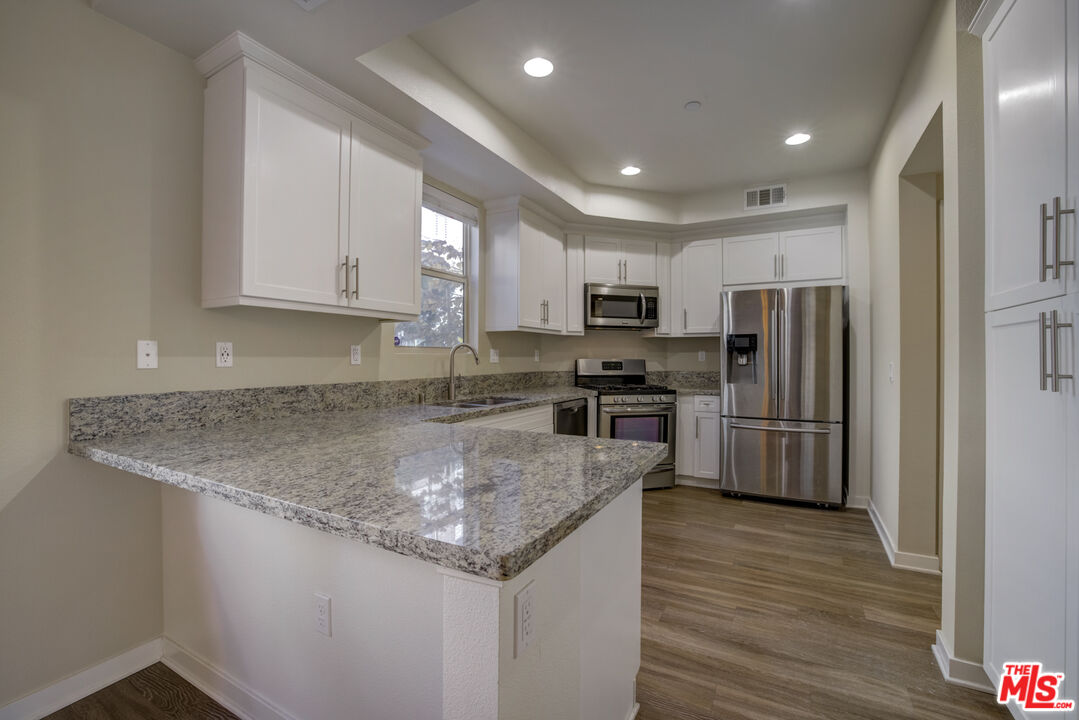 694 Colorado Circle Carson, CA 90745 - Photo 4 of 37 a kitchen with stainless steel appliances granite countertop a refrigerator a sink a stove a microwave and island