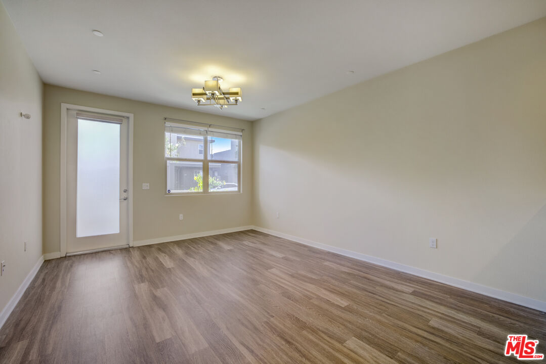 694 Colorado Circle Carson, CA 90745 - Photo 6 of 37 an empty room with wooden floor chandelier and windows