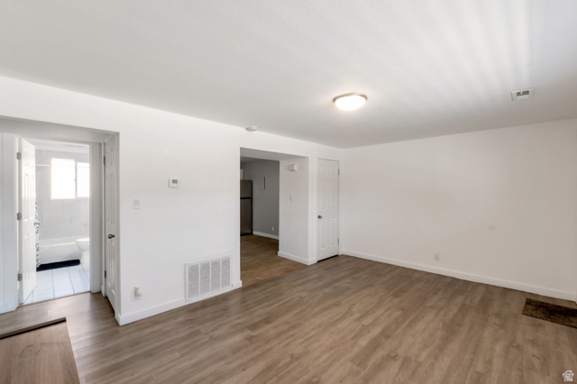 434 South 700 West, Unit 2 Provo, UT 84601 - Photo 9 of 15 Spacious room with wood-finish flooring, white walls, and a ceiling-mounted light fixture