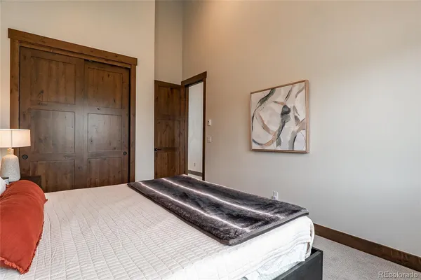 a bedroom with a bed and painting on the wall