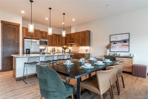 a dining room with stainless steel appliances kitchen island granite countertop a dining table and chairs