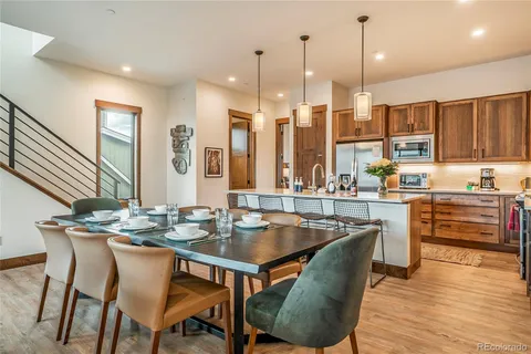 a dining table with chairs and kitchen view