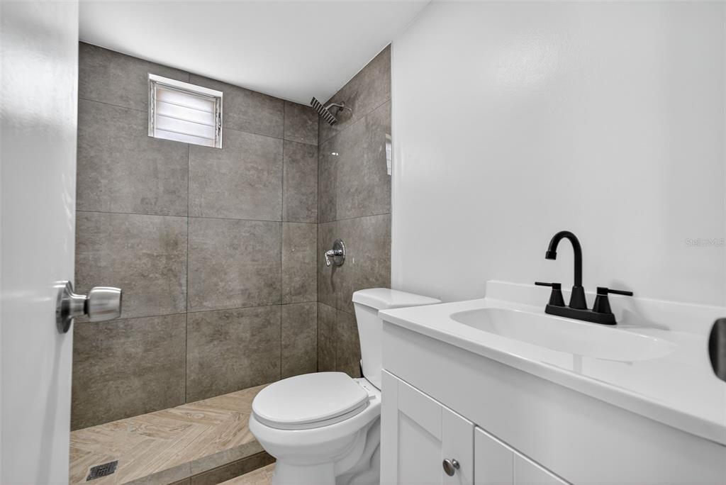 5162 Boca Raton Avenue Sarasota, FL 34234 - Photo 20 of 42 a bathroom with a sink a toilet and a shower