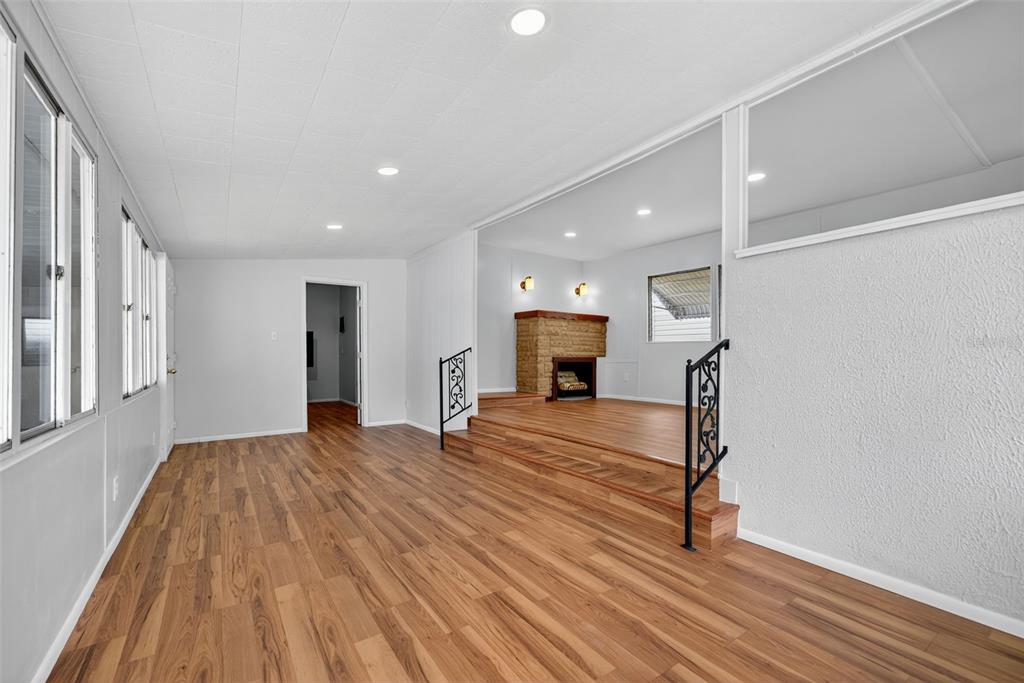 5162 Boca Raton Avenue Sarasota, FL 34234 - Photo 7 of 42 a view of empty room with wooden floor and fireplace