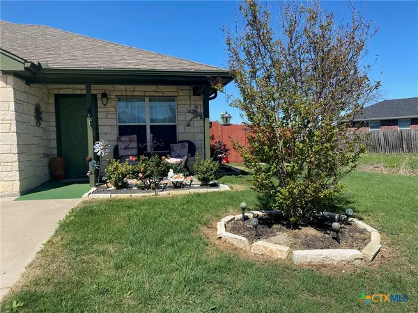 a view of a house with backyard sitting area and garden