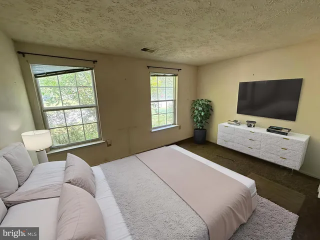 a bedroom with a bed and a television