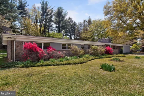 a view of yellow house with a yard and sitting area