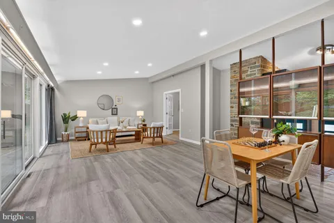 a kitchen with granite countertop a refrigerator oven a sink dishwasher and white cabinets with wooden floor