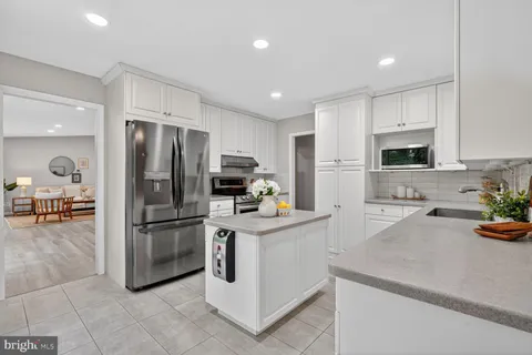 a kitchen with white cabinets and appliances