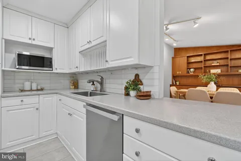 a kitchen with granite countertop a sink stove and cabinets