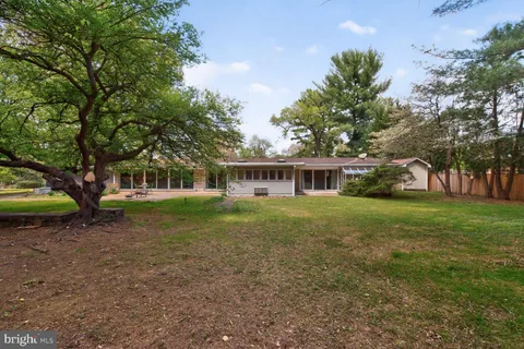 a view of an house with backyard and trees