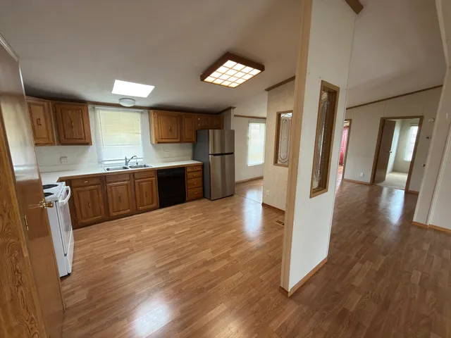 a large kitchen with a wooden floor and cabinets