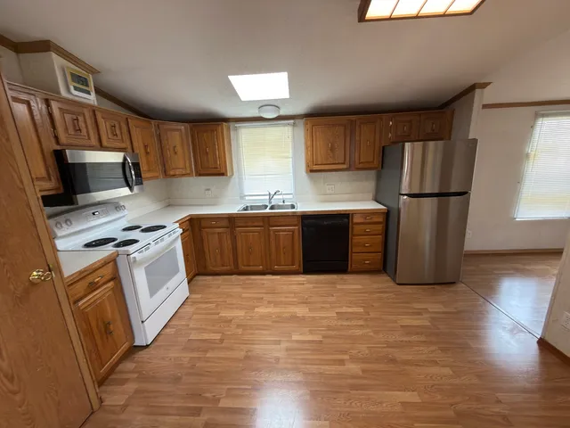 a kitchen with stainless steel appliances granite countertop a refrigerator sink and stove