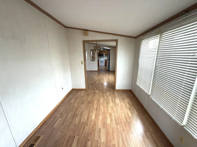 a view of a room with wooden floor and a window