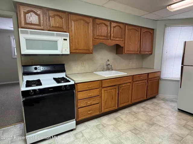a kitchen with stainless steel appliances granite countertop a stove a sink and a microwave