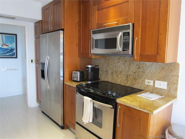 a kitchen with stainless steel appliances granite countertop a stove a refrigerator and a microwave