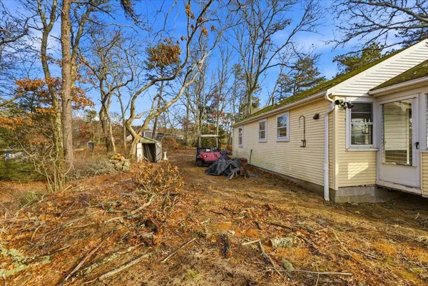 a view of house and a yard with large trees