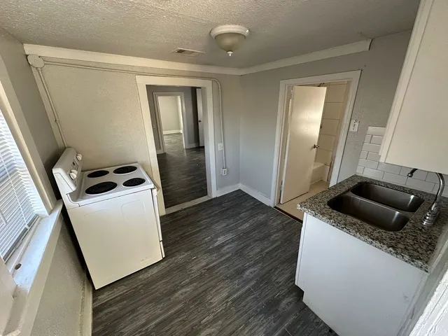 a kitchen with a refrigerator and wooden floor
