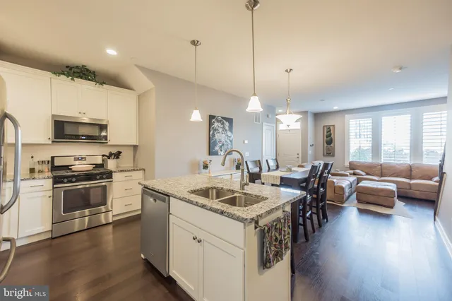 a kitchen with sink stove microwave and wooden floor