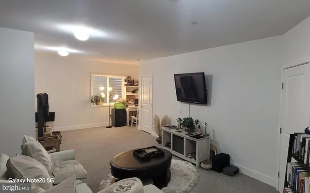 a living room with furniture a flat screen tv and a window