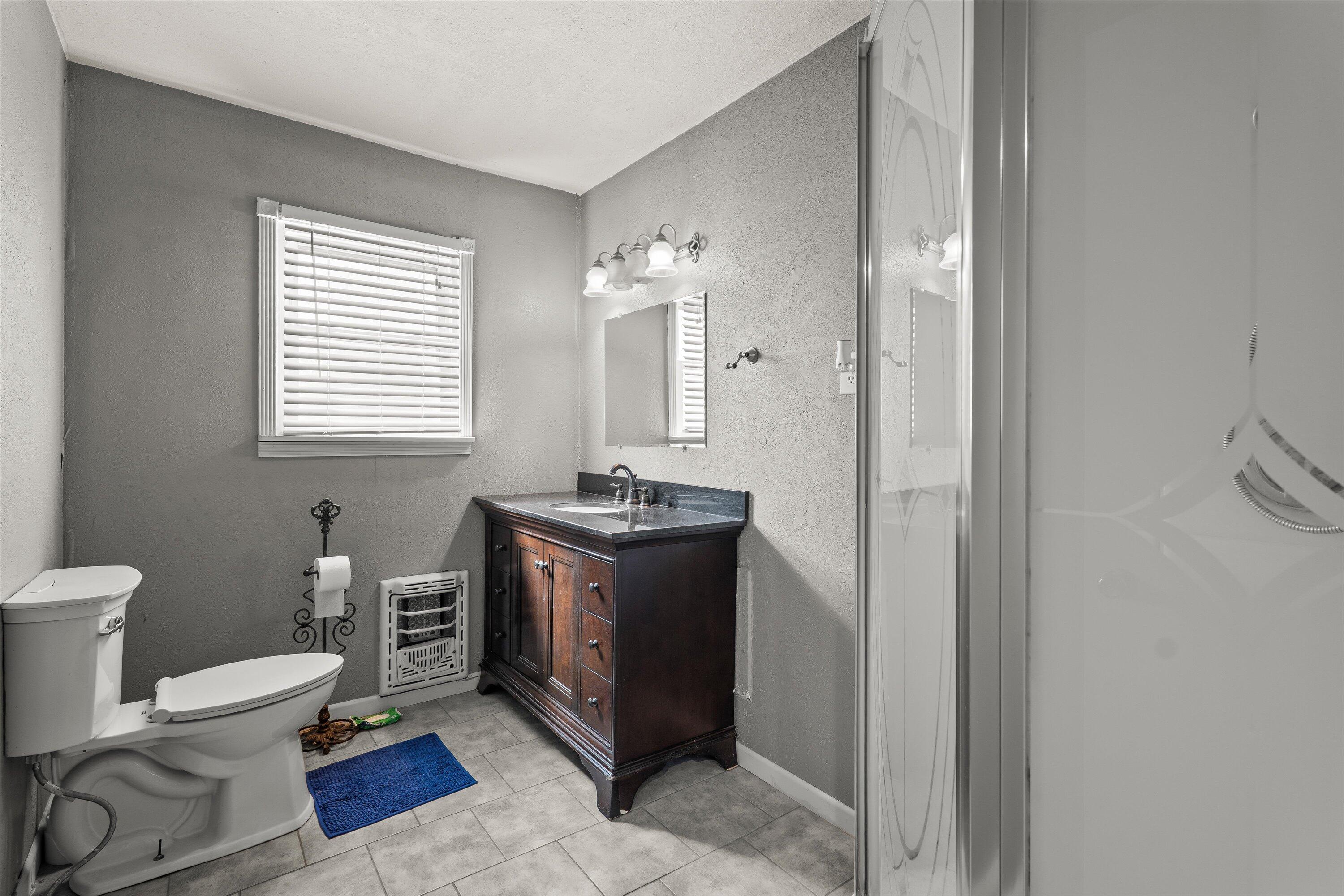 102 3rd Street Plains, TX 79355 - Photo 16 of 29 a spacious bathroom with a double vanity sink and a toilet