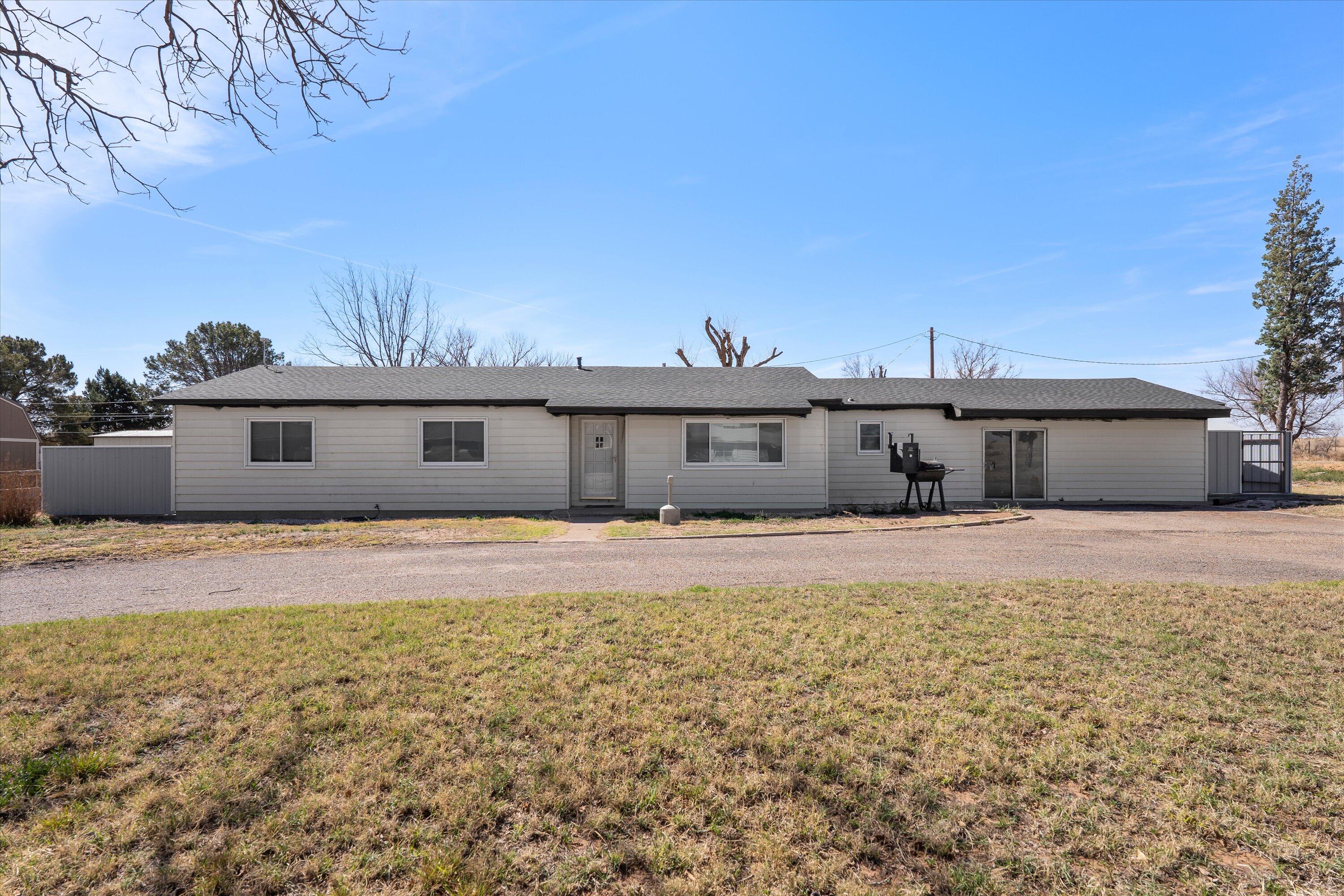 102 3rd Street Plains, TX 79355 - Photo 2 of 29 a front view of a house with a yard and a garage