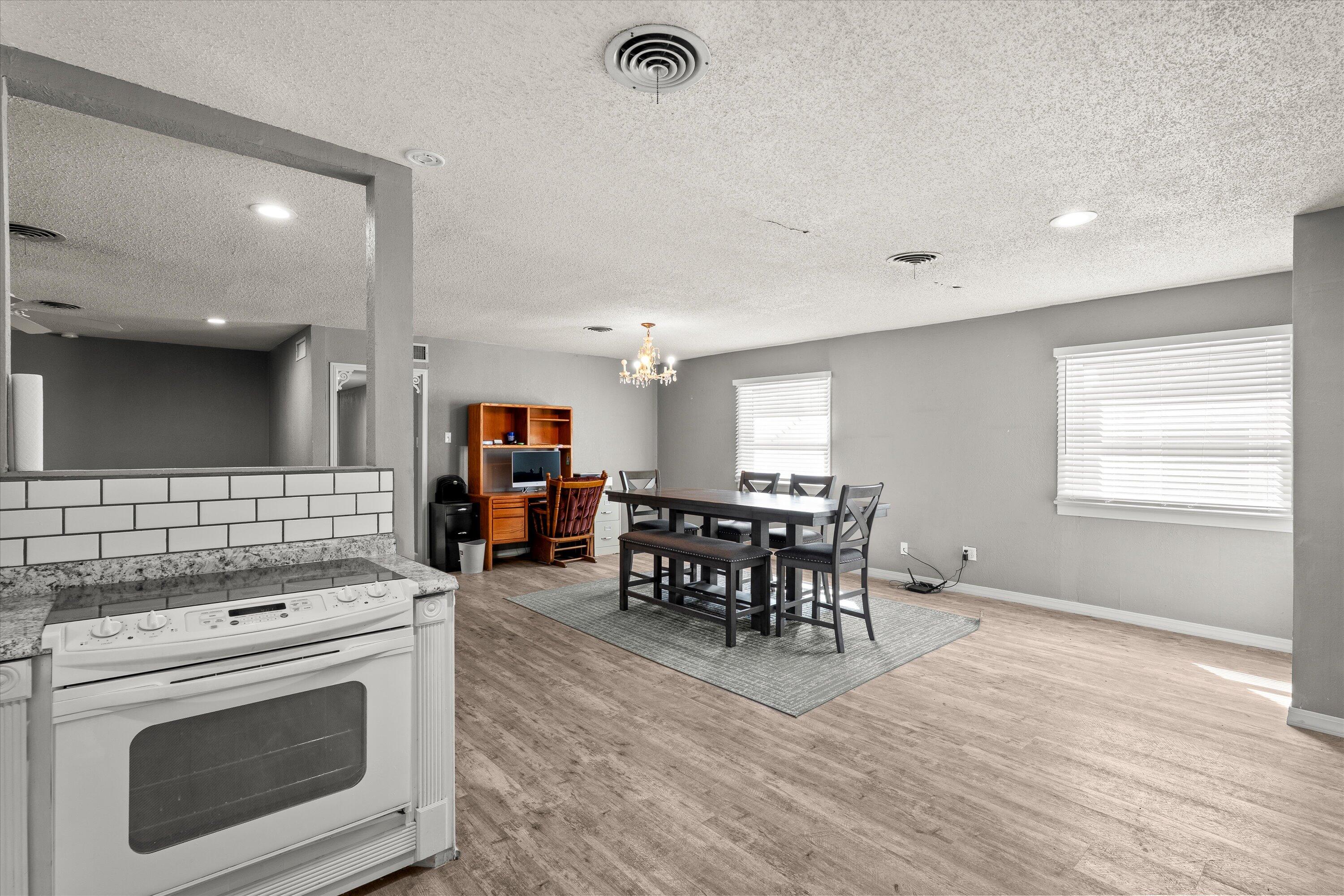 102 3rd Street Plains, TX 79355 - Photo 28 of 29 a kitchen with stainless steel appliances granite countertop a stove and a wooden floors