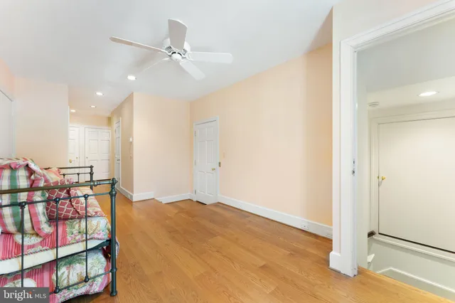 an empty room with windows and ceiling fan