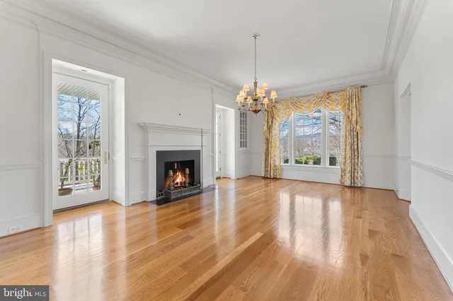 a view of a livingroom with wooden floor and a fireplace