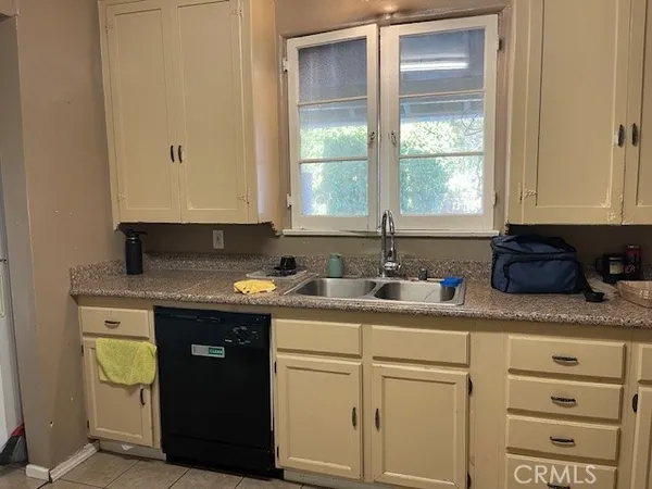 a kitchen with granite countertop cabinets sink and window