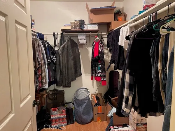 a view of walk in closet with clothes and shoes