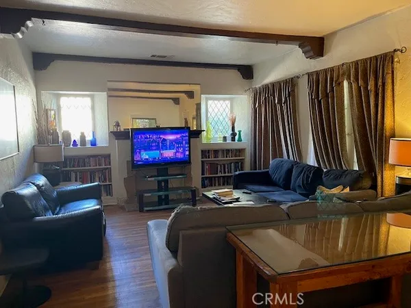 a living room with furniture a flat screen tv and a window