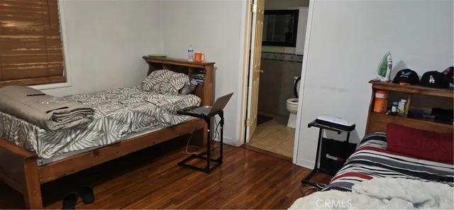 a bed sitting in a bedroom next to a window with wooden floor