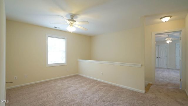 an empty room with a ceiling fan and a window