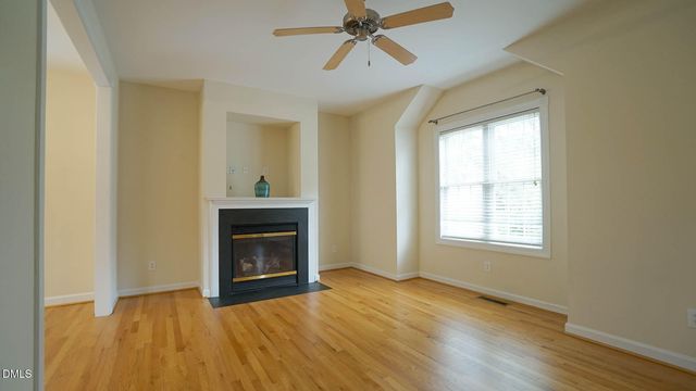 a view of an empty room with a fireplace and a window