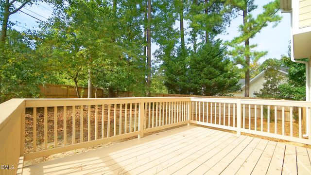 a balcony with wooden floor and fence