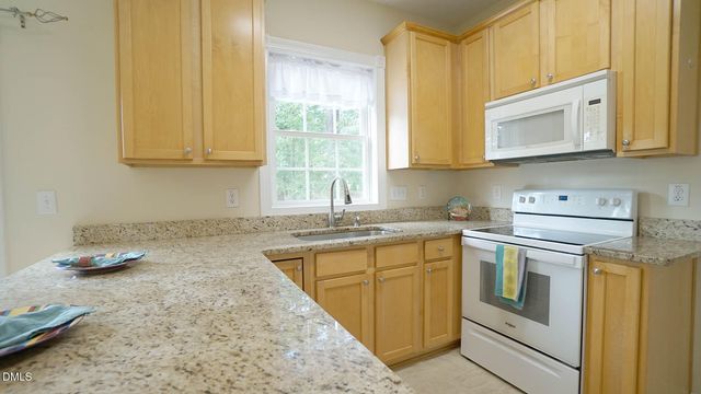 a kitchen with stainless steel appliances granite countertop a sink and a stove top oven