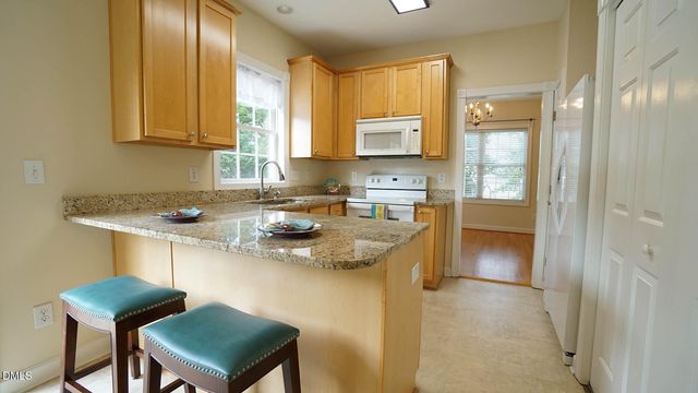 a kitchen with stainless steel appliances granite countertop a sink a stove and a refrigerator