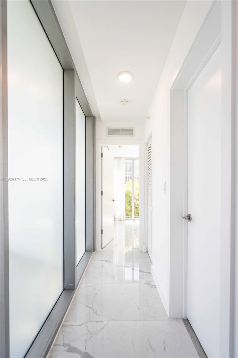 8425 Crespi Boulevard, Unit TH3 Miami Beach, FL 33141 - Photo 10 of 28 a view of a hallway with wooden floor