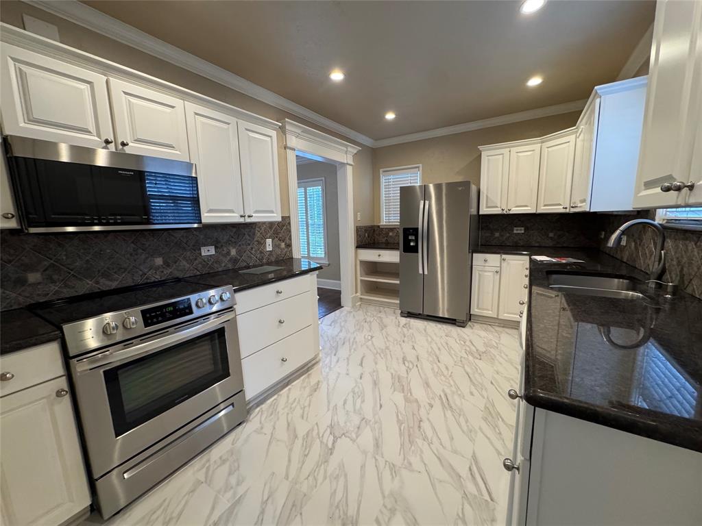 4558 Roland Avenue, Unit B Highland Park, TX 75219 - Photo 4 of 10 a kitchen with a sink stove and refrigerator