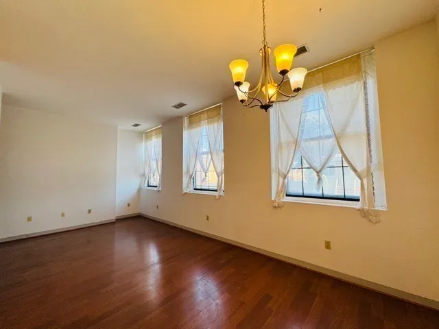 a view of a room with wooden floor and chandelier