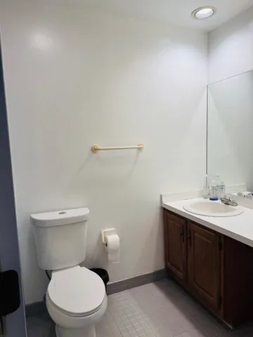 a bathroom with a toilet a sink and mirror