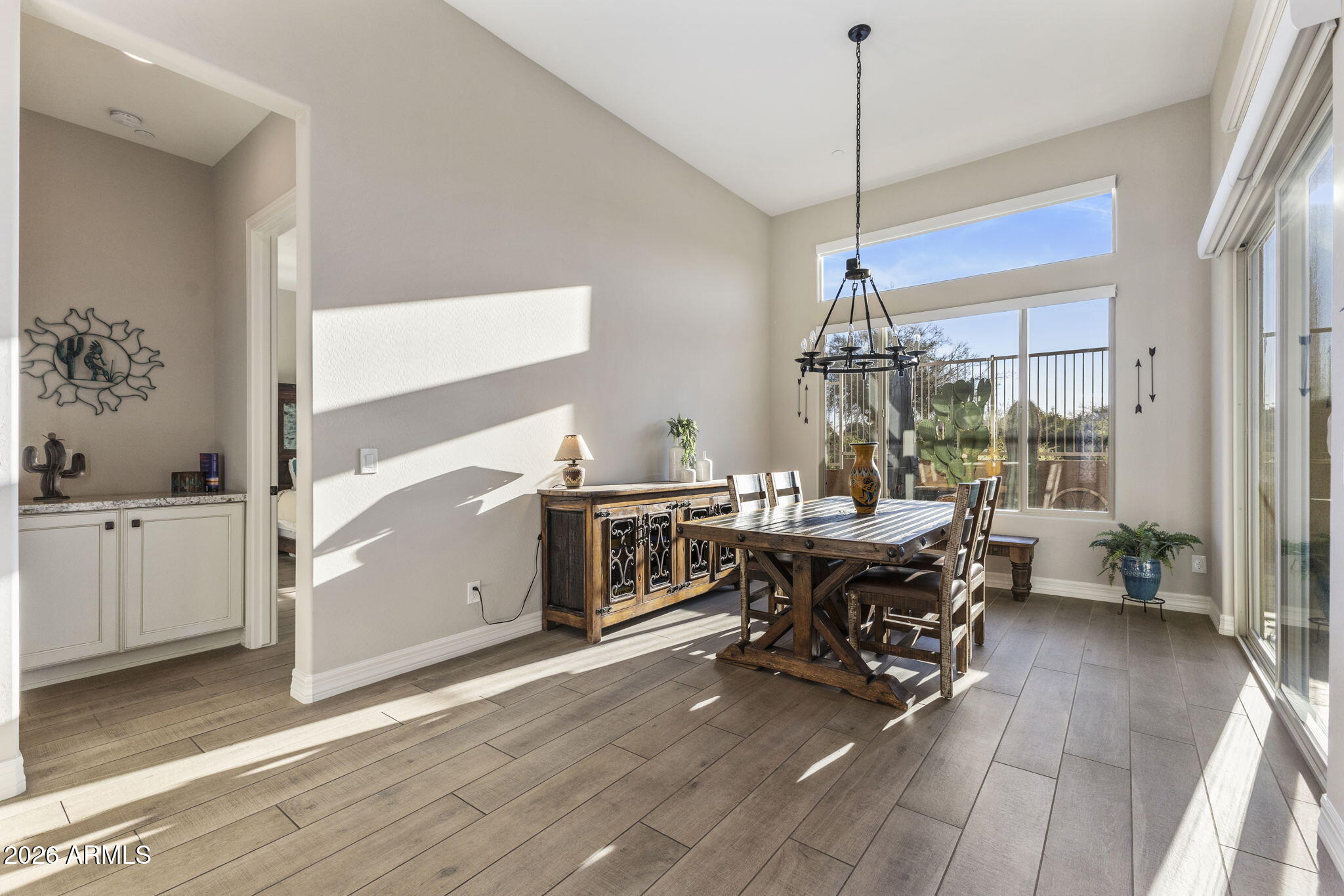 18785 East Blue Sky Drive Rio Verde, AZ 85263 - Photo 7 of 23 a dining room with wooden floor a chandelier a wooden table and chairs