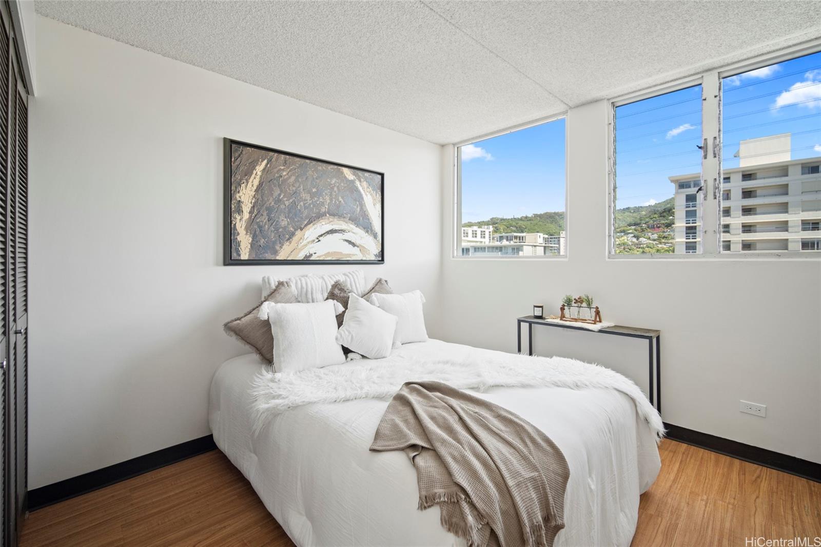 1624 Dole Street, Unit 801 Honolulu, HI 96822 - Photo 10 of 20 a bed room with a bed and a painting