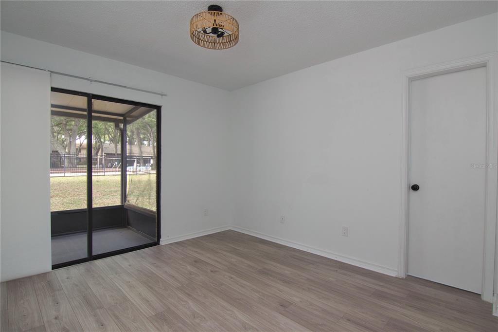 1831 Foxhall Circle Kissimmee, FL 34741 - Photo 5 of 16 an empty room with wooden floor and door