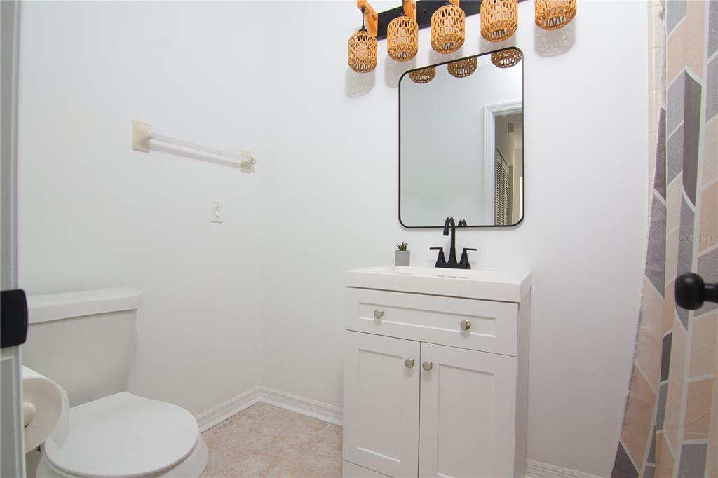 1831 Foxhall Circle Kissimmee, FL 34741 - Photo 9 of 16 a bathroom with a sink a toilet and a mirror