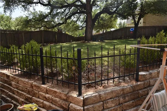 a view of a backyard with a iron fence